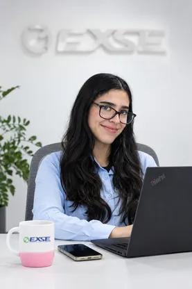 Integrante del equipo EXSE con su laptop y una taza de EXSE